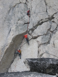 Climbers on Paddle Flake (5.10b), Bugaboos, BC, Canada.