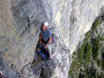 A belay ledge with beautiful exposure on Red Shirt, Yamnuska (5.8+). Bow Valley, Canada.