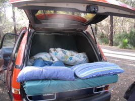 The bed sticks out and is covered by the awning